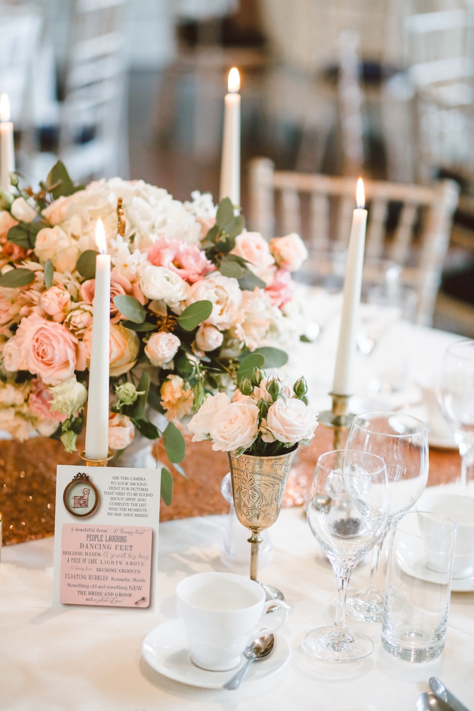 Wedding reception table with floral centerpiece and scavenger hunt card.